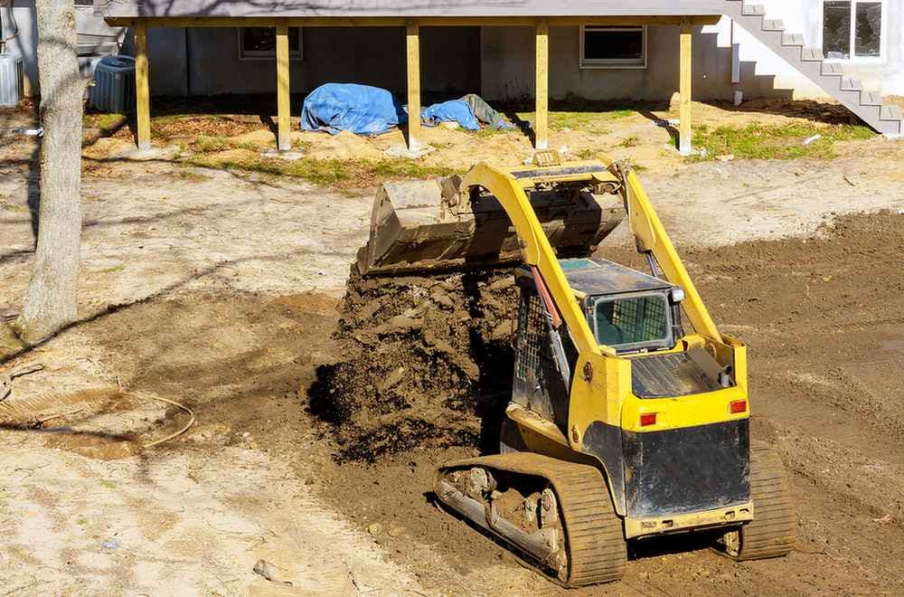 Yellow bulldozer releasing dirt onto the ground