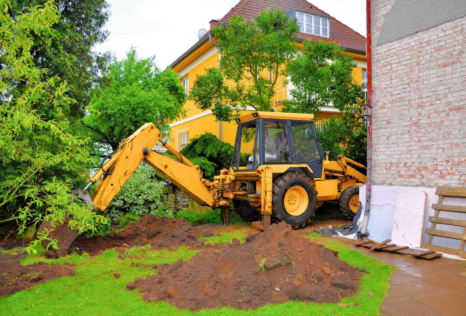 Yellow excavation vehicle removing a tree